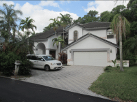 multi-story residential home sitting in front of wooded area