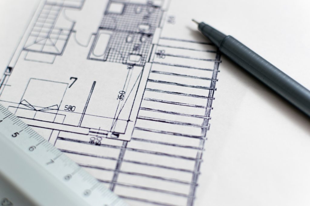 pen and ruler on top of architecture blueprints