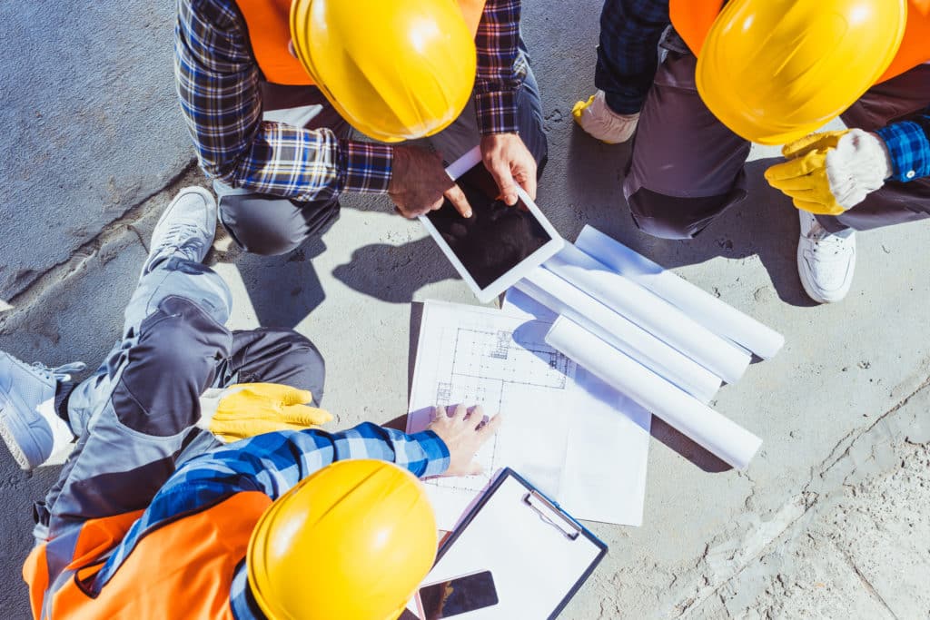 construction workers reviewing building plans