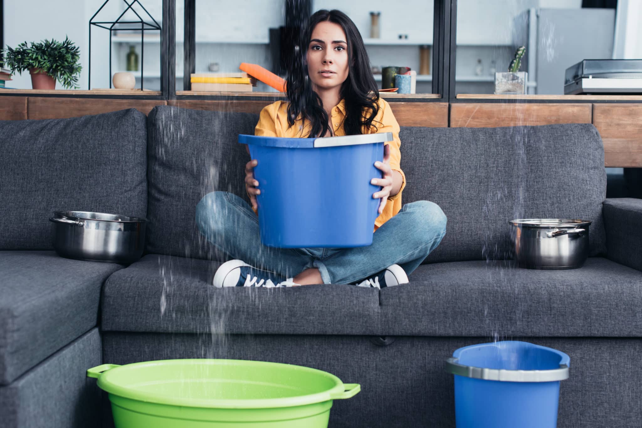 woman collecting water from leak in buckets