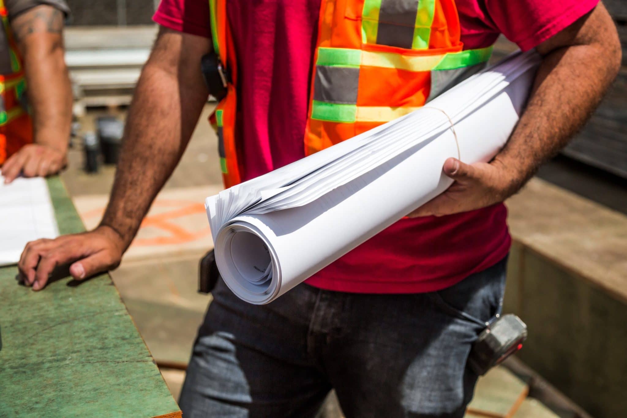 construction worker holding roll of draft paper